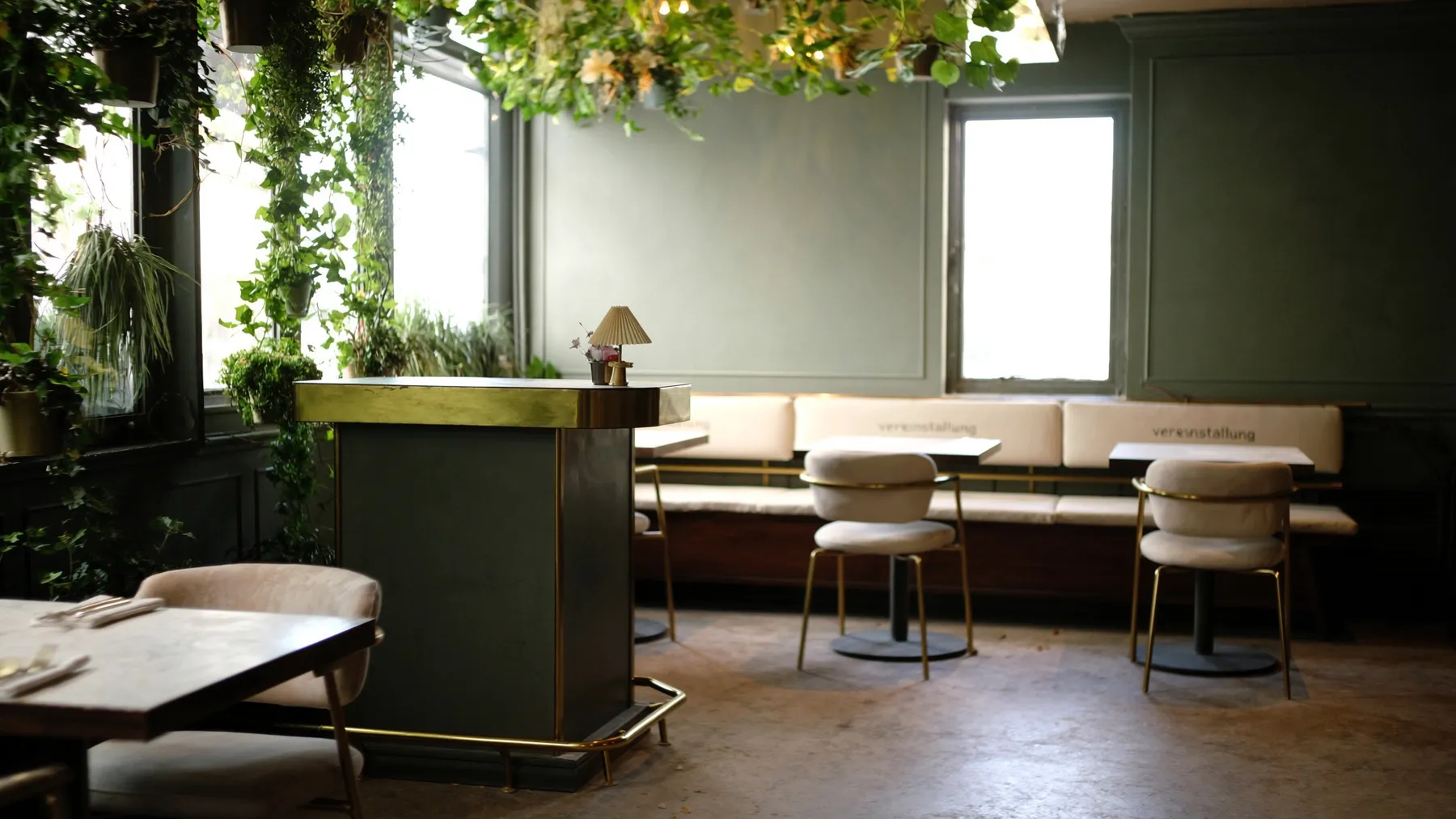 Lichte eetzaal van Brasserie De Kade met planten en houten tafels