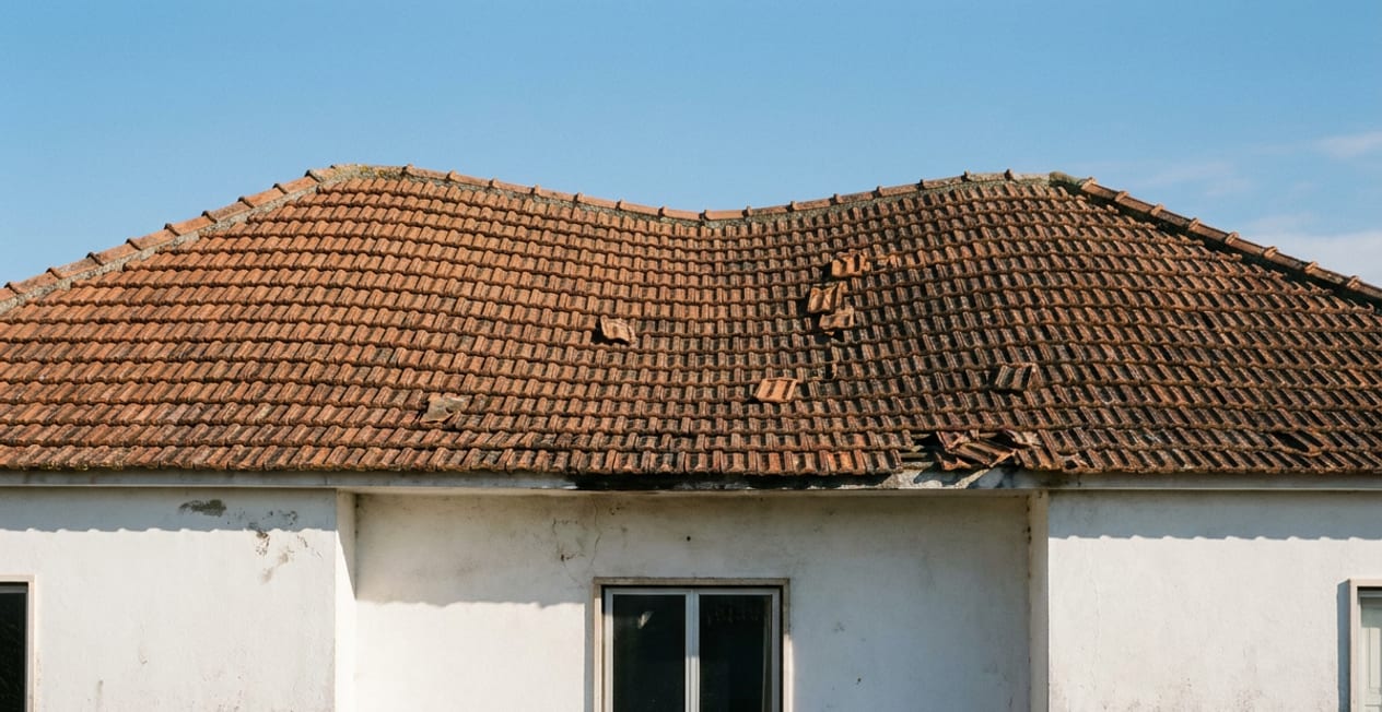 Verweerd dak met versleten pannen vóór renovatie